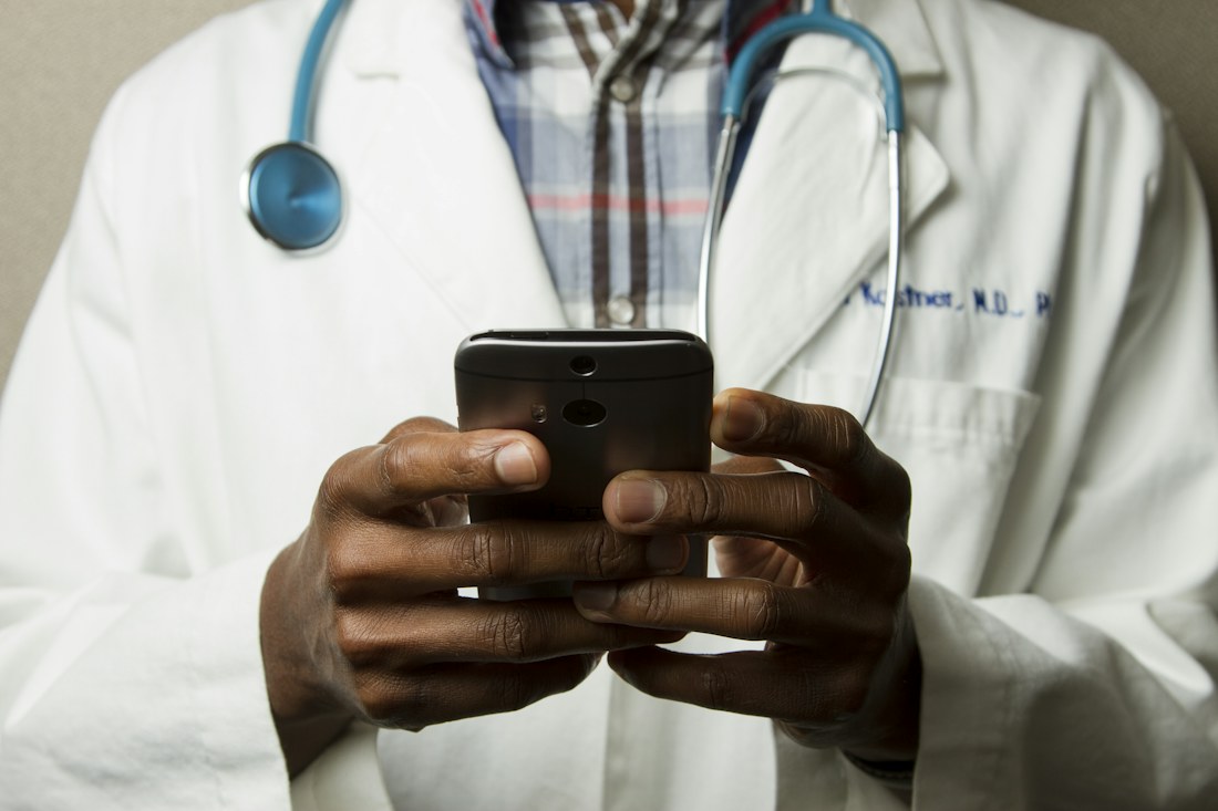 Doctor using a phone to check a patient booking